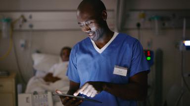 A nurse checking a tablet computer.