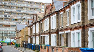 A row of houses in front of a block of flats.