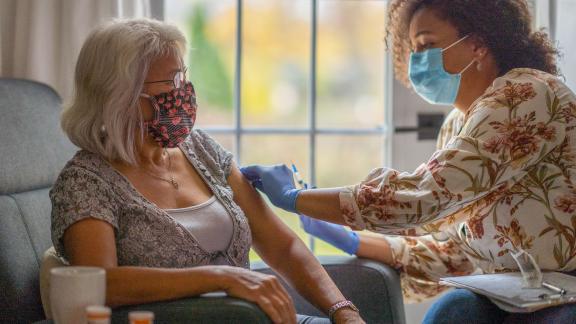 A patient in a mask receives the COVID-19 vaccine.