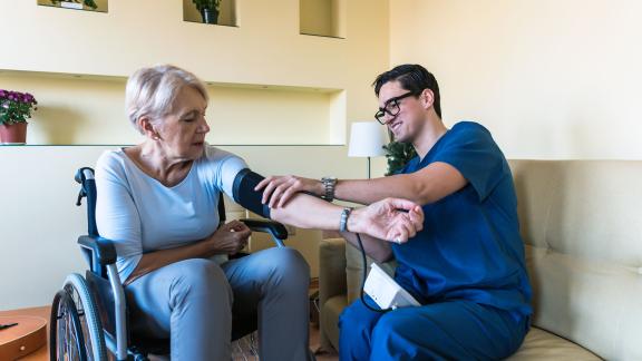 A community nurse checking a patient's blood pressure.