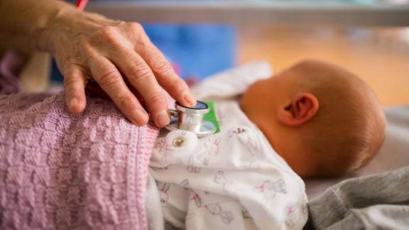 A baby in a hospital cot.