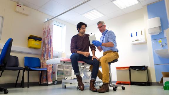 A GP consulting a male patient.