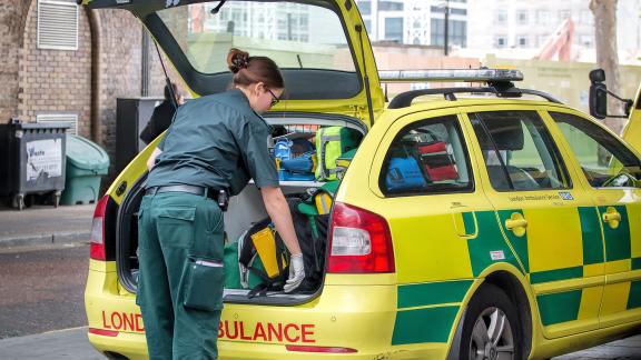 A paramedic getting equipment from an ambulance responder boot.