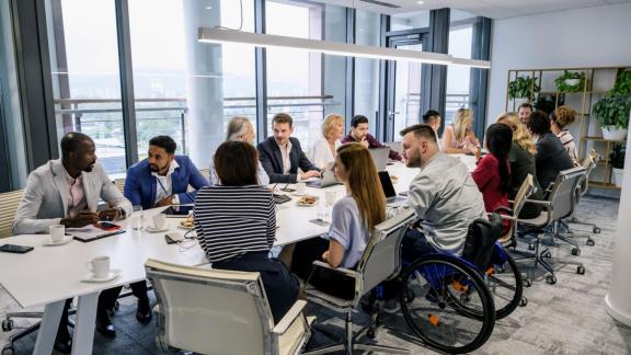 Diverse group sat around a boardroom table