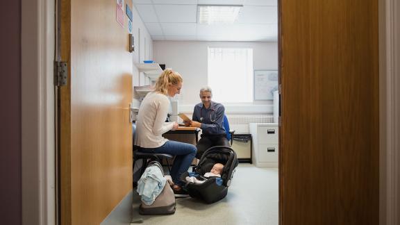 A mother and baby at a GP appointment.