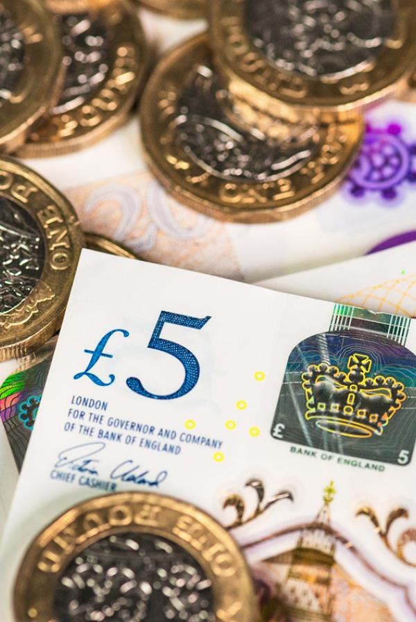 Recently issued UK £5, £10 and £20 polymer banknotes with £1 coins.