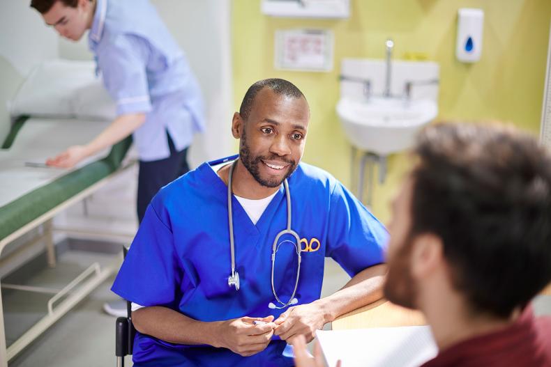 A doctor on a ward, consulting.